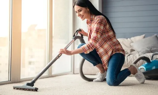 Lady vacuuming carpet | Jubilee Flooring & Decorating